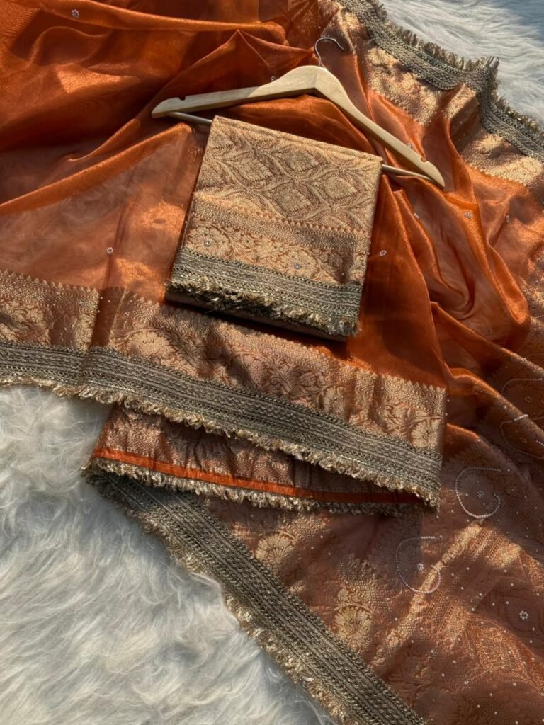 Woman wearing sunset orange Banarasi tissue silk saree with elegant stone work for wedding and festive occasions